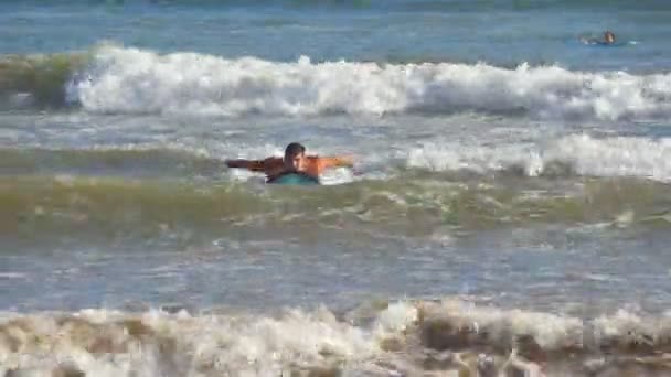 Jonge sportieve vent peddelen uit op ocean wave en leren om te surfen tijdens de reis van de zomer op zonnige dag. Concept van vakantie of vakantie. Close-up — Stockvideo