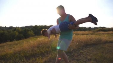 Baba ve oğul güneşli yaz gününde sahada oynuyor. Mutlu baba tutarak ve küçük çocuğunu elinde döner. Çocuk gibi bir uçak uçar hayal. Mutlu bir aile vakit açık. Ağır çekim