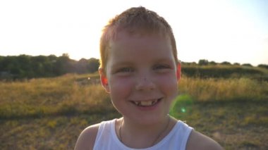 Çilli mutlu kızıl saçlı çocuğun portresi açık havada gülüyor. Sevimli yakışıklı bebek neşeli bir gülümsemeyle kameraya bakıyor. Yüzünde mutlu bir ifade olan erkek çocuğun duygularını kapat. Yavaş çekim