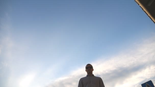 Vista basso angolo di tre uomini d'affari in piedi all'aperto vicino ufficio e parlando. Gli uomini d'affari si incontrano e parlano fuori in città con il cielo blu sullo sfondo. Comunicazione di colleghi felici. Primo piano — Video Stock