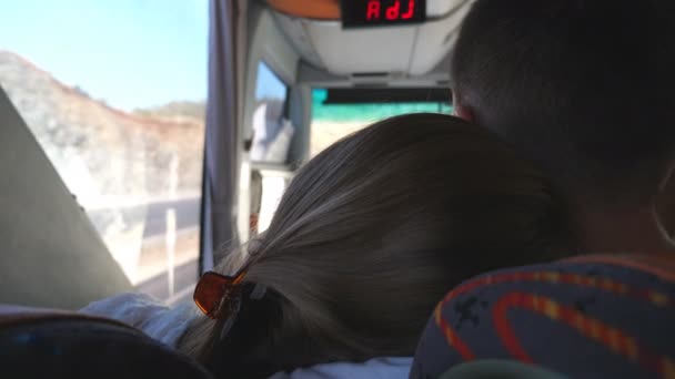 Casal jovem viajando de ônibus no verão. Menina irreconhecível abraçando seu namorado durante a viagem. Par de turistas faz um passeio de autobus. Conceito de férias ou excursão. Fechar para cima Visão traseira — Vídeo de Stock