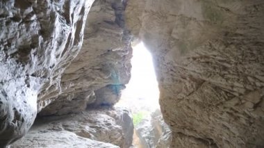 Etrafta duran yüksek gri kayalıkların güzel manzarası. Parlak gökyüzü ışığı kayalık geçidi aydınlatıyor. Manzaranın doğası. Seyahat ya da yürüyüş kavramı. Yavaş çekim Düşük açı görünümü