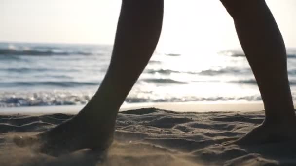 Pernas de mulher indo na praia de areia com bela paisagem marinha no fundo. Close up de pés femininos passeando ao longo da costa oceânica. Menina descalça desfrutando de andar na praia. Conceito de férias de verão. Devagar. — Vídeo de Stock