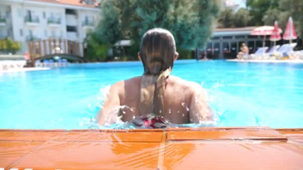 Menina sexy nova nadando em toda a piscina do hotel de luxo. Mulher bronzeada atraente refrescante na bacia durante a viagem de verão. Senhora irreconhecível com corpo bronzeado desfrutando de férias. Lento movimento Fechar — Vídeo de Stock