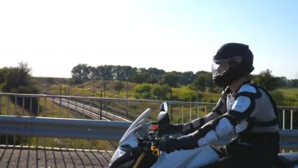 Man in helmet riding fast on powerful sport motorbike at highway. Motorcyclist racing his motorcycle on country road. Guy in moto equipment driving bike during trip. Concept of adventure and freedom — 비디오