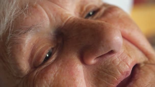 Portrait of elderly woman watching pensive to something. Close up of old female face of grandmother with wrinkle. Slow motion Detail view — Stock Video