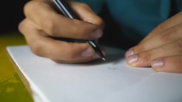 Male hand holds a ball pen and draws black lines in sketchbook. Close up of arm of talented artist paints beautiful abstract image on white paper. Artistic and creativity concept. Slow motion — ストック動画