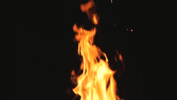 Φωτεινές φλόγες αναδύονται από την καύση φέτες ξύλου και κάρβουνο σε μάνγκο τη νύχτα. Καυσόξυλα και κάρβουνα καίγονται σε μπάρμπεκιου σε μαύρο φόντο. Έννοια της ζεστασιάς και ηρεμίας. Κλείσιμο Αργή κίνηση — Αρχείο Βίντεο