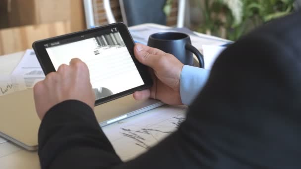 Mãos masculinas de jovem empresário desenvolvendo um projeto de negócios e analisando informações estatísticas em um tablet pc. Empreendedor de sucesso trabalhando em um dispositivo digital moderno no escritório. Fechar — Vídeo de Stock