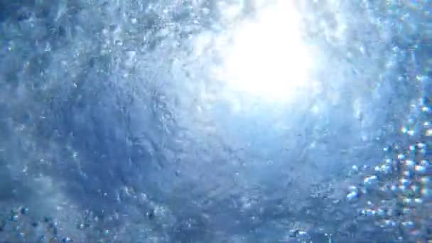 Bulles d'air flottant jusqu'à la surface de l'eau. De nombreuses petites bulles d'air s'élèvent dans la mer turquoise pure. Soleil chaud pénétrant l'eau cristalline de l'océan par une journée ensoleillée d'été. Ralenti Fermer — Video