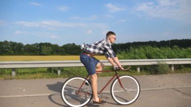 Ülkede yol Vintage Bisiklet sürme yakışıklı delikanlı. Sportif adam pistte Bisiklete binme. Erkek bisikletçi sabit sürme karayolu Bisiklet dişli. Sağlıklı aktif yaşam tarzı ağır çekim