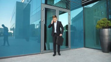 Evrak çantalı genç bir işadamı telefonla konuşuyor ve koşmaya başlıyor. Kendine güvenen adam buluşmaya geç kaldı. Takım elbiseli bir ofis çalışanı modern binanın yanında çalışır. Randevu için acele eden yakışıklı adam. Yavaş çekim