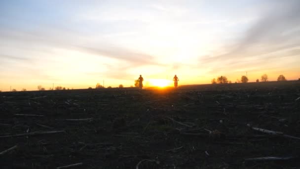 Silhouet van twee motorrijders die vanaf zonsondergang op hun motor rijden. Mannen hebben actieve rust buiten rijden krachtige motorfietsen in de schemering. Motorrijders genieten van de reis. Extreem sport concept. Scenic view — Stockvideo