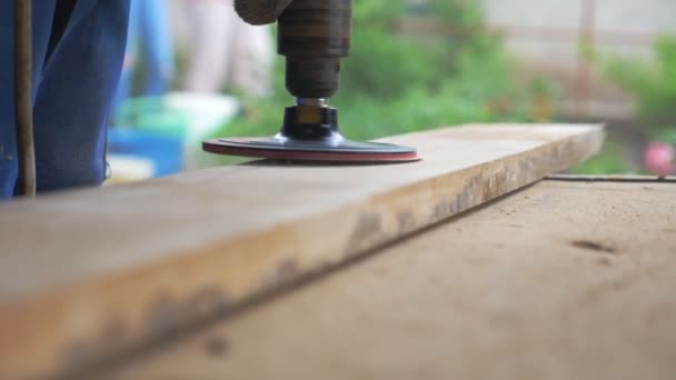 Close up of wood processing. Unrecognizable carpenter working in his workshop. Artisan processing workpiece for some wooden product. Blurred background with sawdust flying around. Slow motion Low view — Stock Video