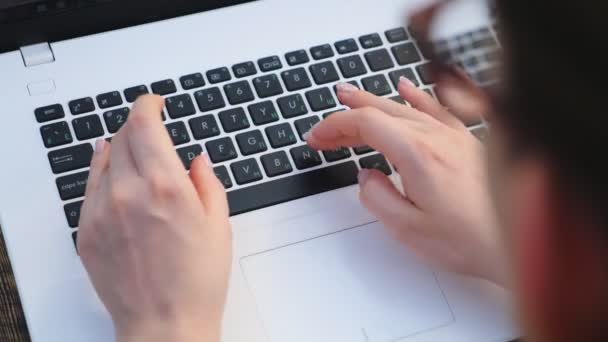 Horní pohled na ženské ruce psaní nějaký text na klávesnici notebooku. Žena pracující venku v laptopu. Dívka procházení internetu nebo komunikace s někým. Creative na volné noze pomocí PC. Zpomalený pohyb — Stock video