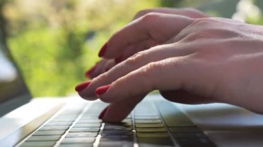 Dişi eller dizüstü bilgisayarın klavyesinde yazı yazıyor. Defterde çalışan bir kadın. Biriyle sohbet eden ya da internette gezinen bir kız. Doğada bilgisayar kullanan yaratıcı bir serbest yazar. Bulanık arkaplan