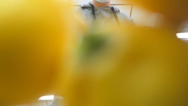 Hombre con mascarilla médica seleccionando limones en el supermercado. Un tipo tomando fruta del mostrador en la tienda de comestibles. Comprador seleccione la comida en el departamento de productos de la tienda. Vida útil frente al coronavirus y la pandemia — Vídeos de Stock