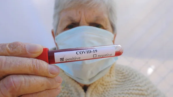 戴着防护面具的老太太进行血液检测结果呈阳性生病的奶奶看着摄像机 露出忧郁的情绪 Covid 19大流行病的健康和安全寿命概念 — 图库照片
