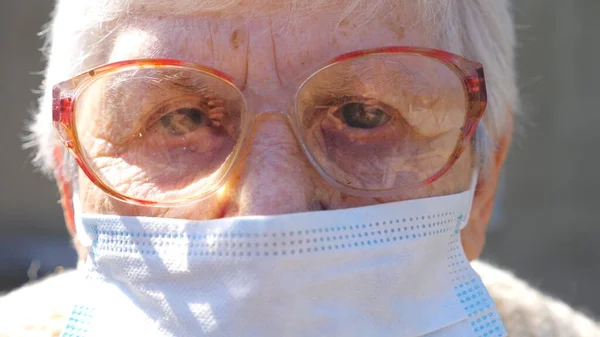 바이러스로부터 마스크를 가입자의 여자는 감정을 카메라를 세계적 유행병으로부터의 안전에 노인들의 — 스톡 사진