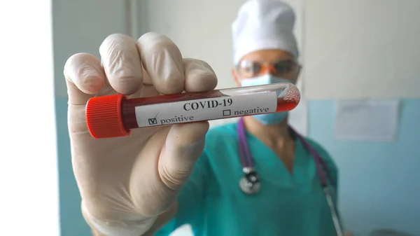年轻医生用血样显示试管给验尸官Covid 戴防护手套的医生在医院或实验室保存血液样本 流行病造成的健康和安全寿命概念 — 图库照片
