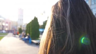 Tanımlanamayan esmer kız sabahın köründe işe gidiyor. İşe giderken şehirde gezinen çekici bir kadın. Koyu saçlı bayana yakın durun. Arka plan bulanık. Yavaş çekim Arka plan Arkası