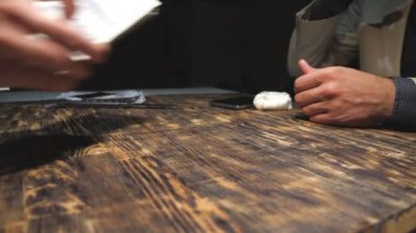 Müşterinin erkek eli masaya bir tomar yabancı para koyuyor. Uyuşturucu satıcılarının silahları para alıyor, müşterilere kokain veriyor ve birbirleri için el sıkışıyorlar. Dolly çekim ağır çekim