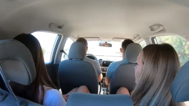 Deux jeunes couples voyageant en voiture ensemble. Hommes et femmes assis à l'intérieur des voitures pendant le voyage sur la route. Amis conduisant en voiture en vacances d'été. Concept de voyage. Coup de feu de dos. Temps écoulé — Video