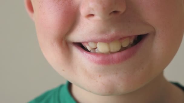 Zár-megjelöl-ból fiatal gyerek mosolyog. Jóképű fiú arcán boldog kifejezés portréja. Részlet nézet a boldog gyermek arcát. Lassú mozgás — Stock videók