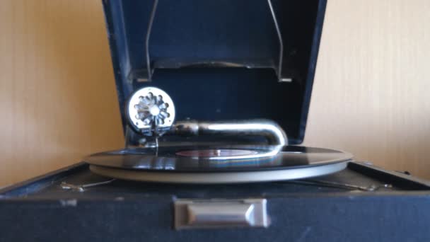 Pohled zepředu na starý gramofon. Jehla hladce klouže po černé vinylové desce, točící se na vinobraném otočném stole. Retro koncept. Uzavření pomalého pohybu — Stock video