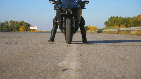 身穿头盔和皮夹克的年轻自行车手坐在高速公路上的摩托车上 准备骑马 男子将骑摩托车参加体育活动 自由和冒险的概念 靠近点 — 图库照片