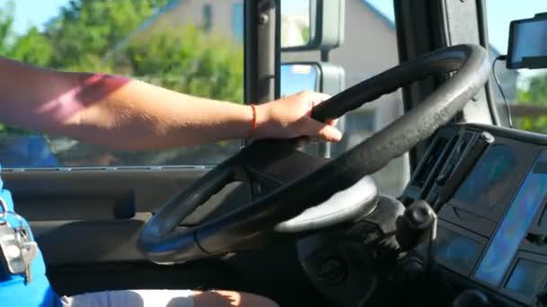 Onherkenbare bestuurder houdt zijn handen op het stuur en het besturen van vrachtwagen op land weg op zonnige dag. De man die de truck bestuurt rijdt naar de bestemming. Detailweergave van het stuur van de vrachtwagen. Langzaam. — Stockvideo