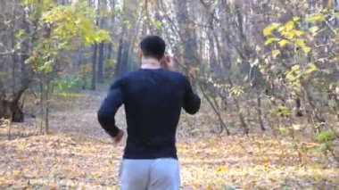 Orman yolunda koşan tanınmayan bir adam. Erkek sporcu doğada çalışıyor. Güçlü ve dayanıklı bir sporcu dışarıda kardiyo eğitimi alıyor. Aktif yaşam tarzı konsepti. Arka plan