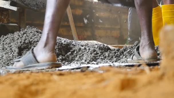 Costruttori indiani locali raccoglie cemento bagnato con pale al mucchio in cantiere. Gli uomini adulti irriconoscibili lavorano su area di costruzione. Concetto di progetto futuro. Vista bassa rallentatore — Video Stock