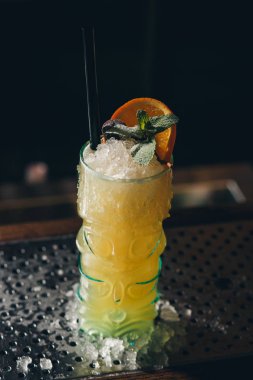 Sarı kokteyl nane yaprağı ile dekore edilmiştir.