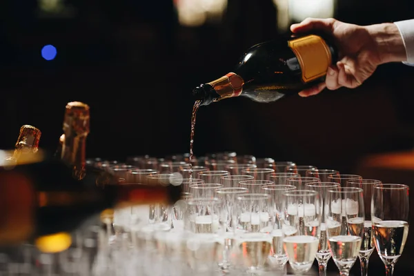 Cantinero verter champán o vino en copas de vino en la mesa al aire libre solemne ceremonia de boda — Foto de Stock
