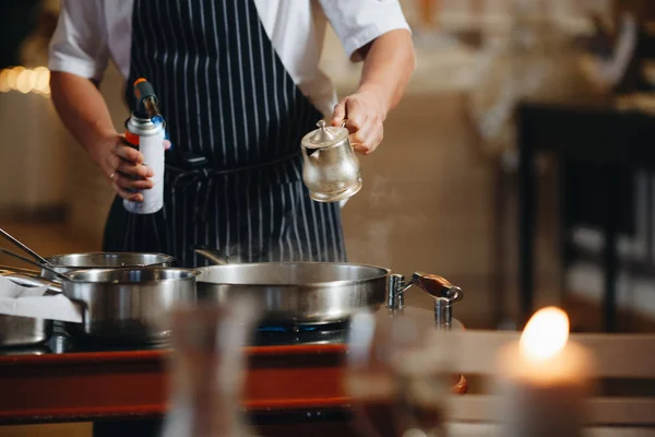 The chef prepares food in front of the visitors in the restaurant close up. — Stock Photo, Image