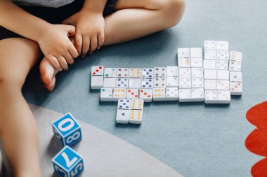 Küçük bebek odasında yerde domino oynuyor..