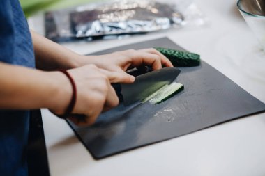 Erkek eller suşi rulosu için sebze kesiyor.