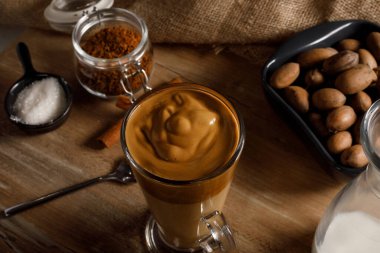 Dalgona kahvesi. Tahta arka planda Kore kahvesi. Şeker ve sıcak suyla çırpılmış kahve ya da espresso tozu. Buzlu dalgona kahve konsepti..