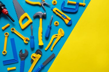 Oyuncakların geçmişi. Mavi sarı arkaplanda, metin için kopyalama alanı olan oyuncak araçlarının üst görünümü.