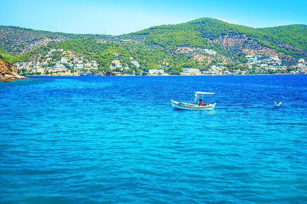 ギリシャの海岸にエーゲ海のターコイズブルーの水で伝統的な漁船. — ストック写真