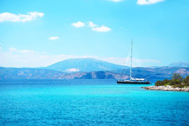 Turkuaz deniz sularında beyaz yelkenli yelkenli Katamaran yatı..