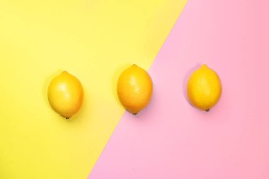 Parlak sarı ve pastel pembe arka planda limonlardan oluşan yaratıcı desen.