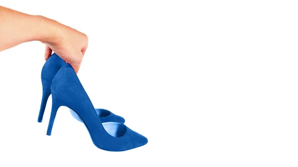 Mujer sostiene zapatos azules de moda en su mano, aislados . —  Fotos de Stock