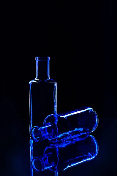 Empty classic blue color bottles isolated on dark background. — Stock Photo, Image