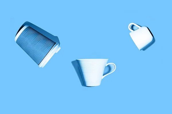 Coffee pattern of white ceramic and blue paper cup for coffee on classic blue background.