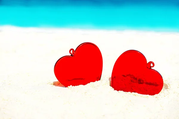 Cuori rossi sulla spiaggia di sabbia bianca gialla. Concetto d'amore per San Valentino . — Foto Stock