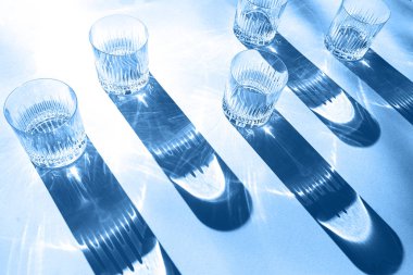 Klasik mavi arkaplanda gözlük ve gölgelerle yapılan moda renk deseni.