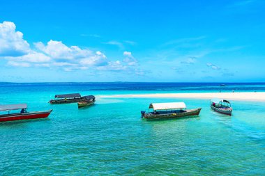 Kumlu sahilde güneşli güzel bir günün panoramik manzarası ve Zanzibar 'da balıkçı tekneleri.