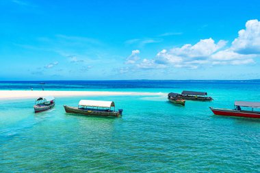 Kumlu sahilde güneşli güzel bir günün panoramik manzarası ve Zanzibar 'da balıkçı tekneleri.